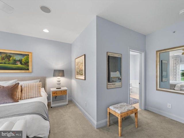 bedroom with light colored carpet and ensuite bathroom