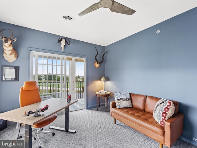 carpeted home office featuring ceiling fan