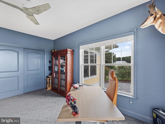 carpeted office space featuring ceiling fan and a healthy amount of sunlight