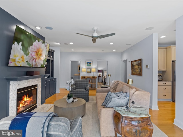 living room with light hardwood / wood-style flooring and ceiling fan