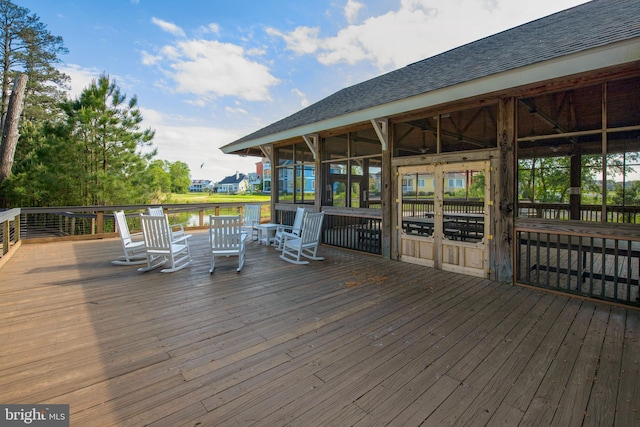 deck featuring a sunroom and a water view