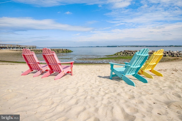 view of home's community featuring a water view and a beach view