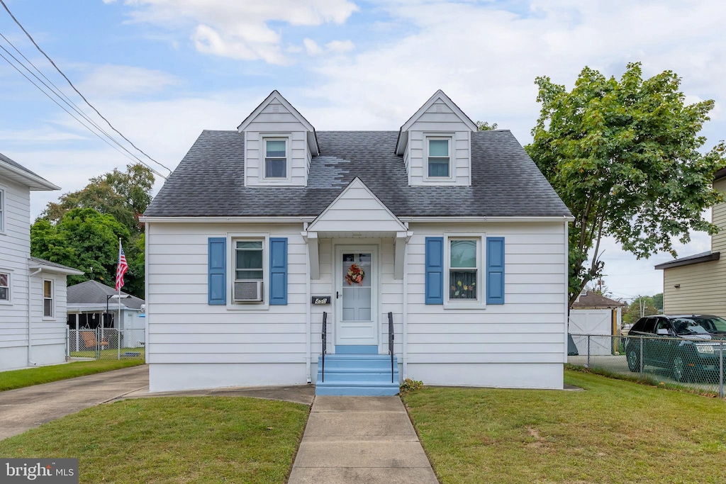 cape cod home featuring a front yard