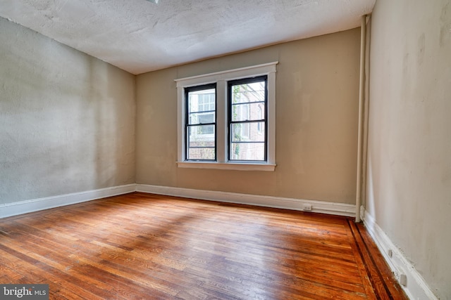 unfurnished room featuring a textured ceiling and hardwood / wood-style flooring