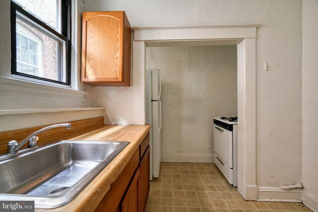 kitchen featuring white appliances and sink