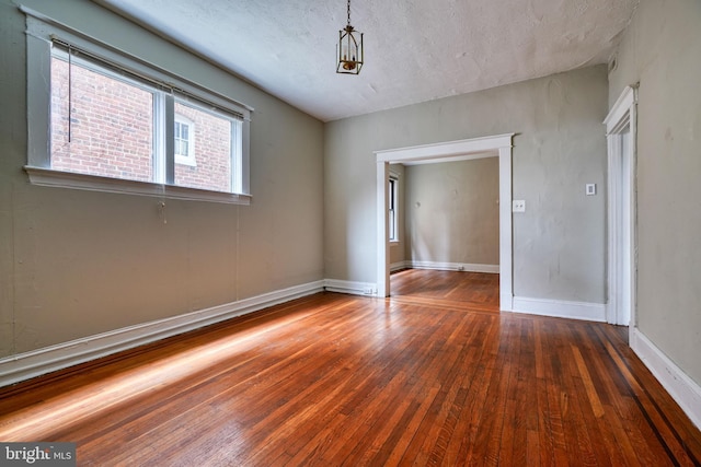 empty room featuring wood-type flooring and baseboards