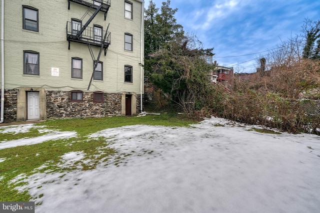 snowy yard featuring a balcony