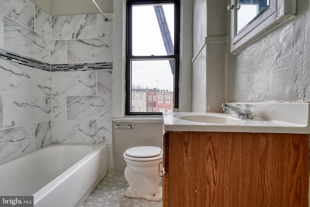 bathroom with tile walls, vanity, toilet, and tile patterned floors