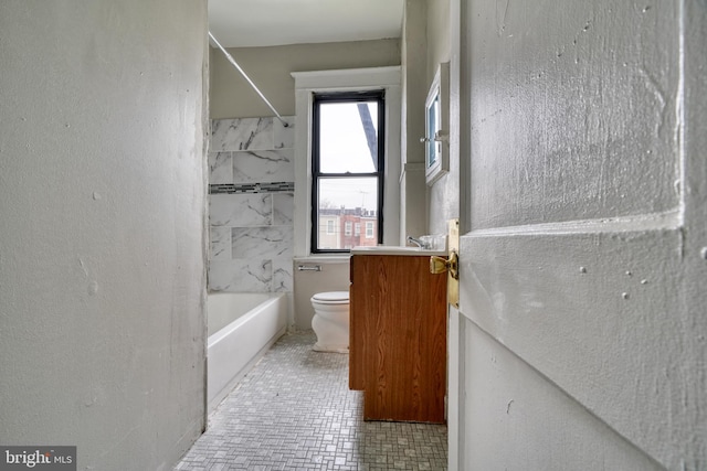 full bathroom with tile patterned floors, tiled shower / bath, vanity, and toilet