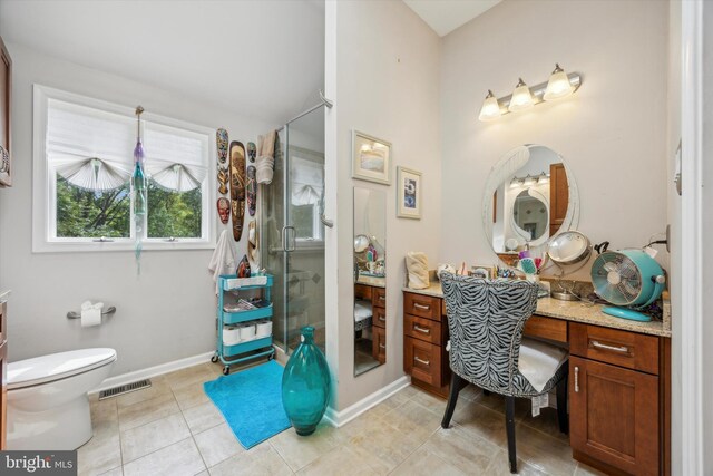 bathroom with tile patterned floors, a shower with shower door, vanity, and toilet