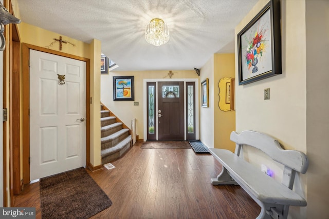 entrance foyer featuring a textured ceiling and dark wood-type flooring