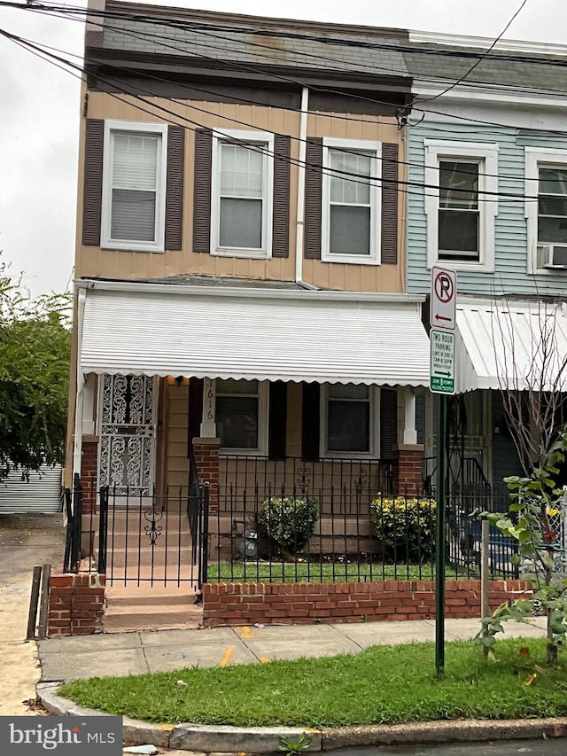 townhome / multi-family property featuring cooling unit and a porch