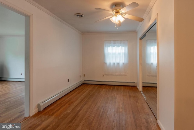 unfurnished room with crown molding, a baseboard heating unit, ceiling fan, and light hardwood / wood-style flooring