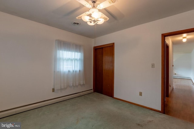 spare room featuring ceiling fan, light colored carpet, and baseboard heating