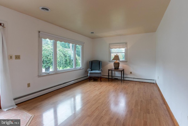 unfurnished room featuring light hardwood / wood-style flooring and baseboard heating