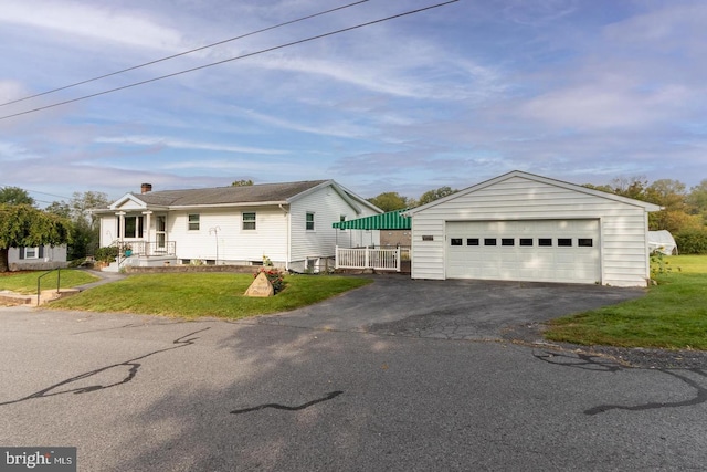 view of front of home featuring a garage, an outdoor structure, and a front lawn