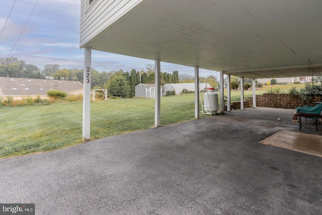 view of patio featuring a storage unit and a carport