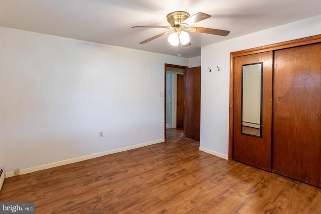 unfurnished bedroom featuring wood-type flooring, ceiling fan, and a closet