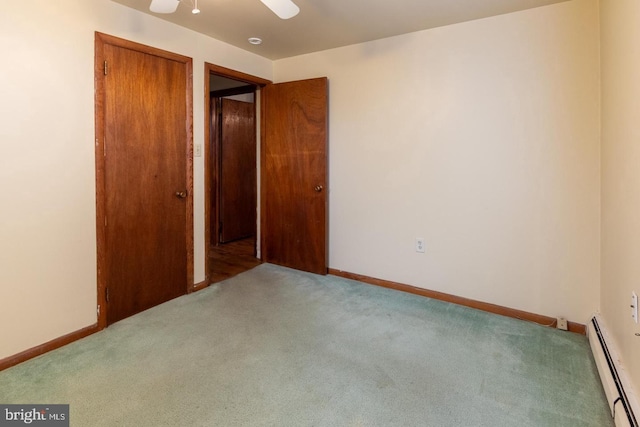 carpeted empty room with a baseboard heating unit and ceiling fan