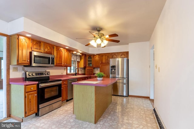 kitchen with a center island, sink, backsplash, appliances with stainless steel finishes, and ceiling fan