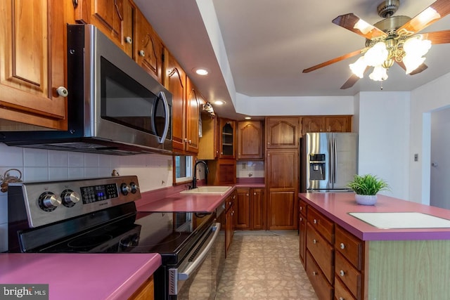 kitchen featuring ceiling fan, stainless steel appliances, backsplash, and sink