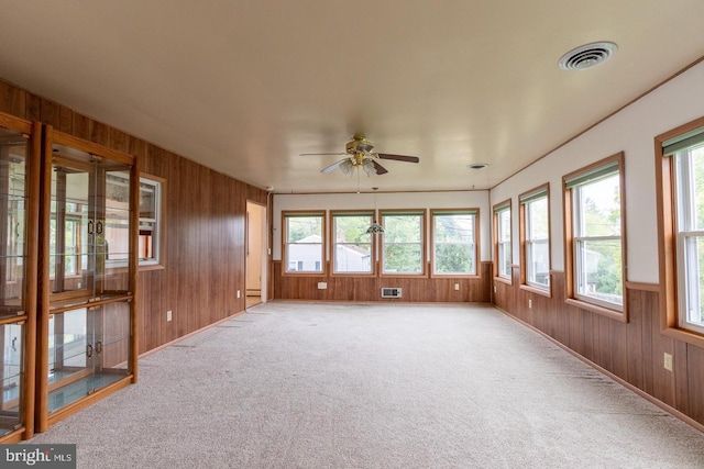 unfurnished sunroom featuring a wall unit AC and ceiling fan