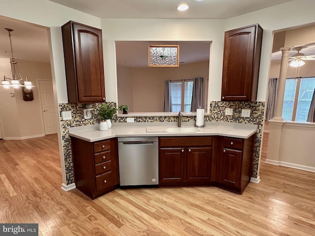 kitchen with light hardwood / wood-style flooring, ceiling fan with notable chandelier, hanging light fixtures, and stainless steel dishwasher