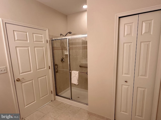 bathroom featuring tile patterned flooring and a shower with shower door