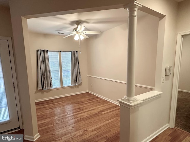 spare room featuring ceiling fan, hardwood / wood-style flooring, and ornate columns