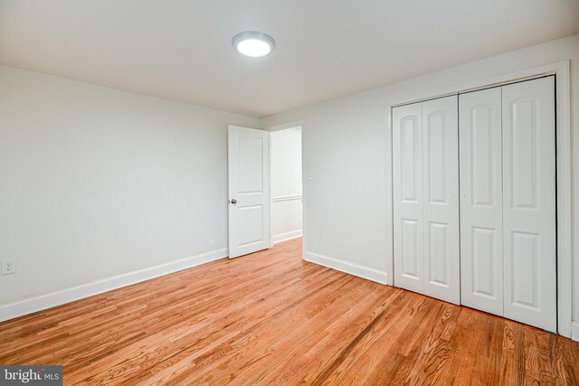 unfurnished bedroom featuring a closet and light hardwood / wood-style floors