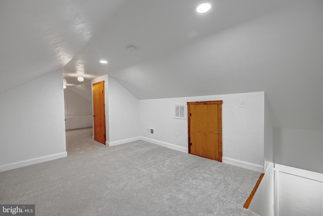 bonus room with light carpet and vaulted ceiling