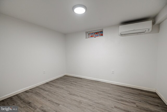 basement with hardwood / wood-style flooring and a wall mounted AC