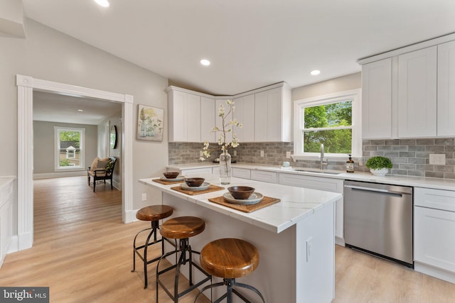 kitchen featuring white cabinets, dishwasher, and a wealth of natural light