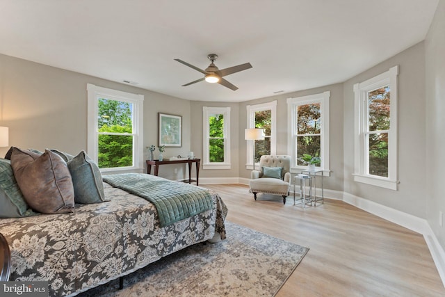 bedroom with light hardwood / wood-style floors, multiple windows, and ceiling fan