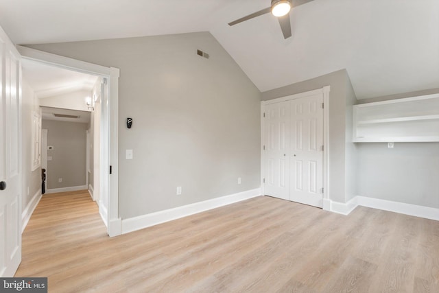 unfurnished bedroom with light wood-type flooring, vaulted ceiling, and ceiling fan