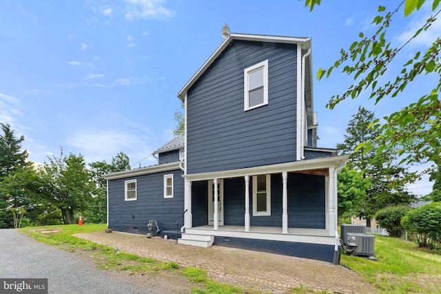 rear view of house with a porch and central AC