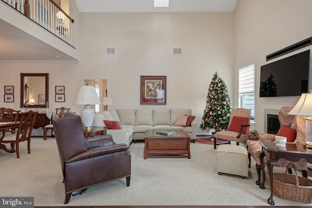 carpeted living room with ornamental molding and a high ceiling