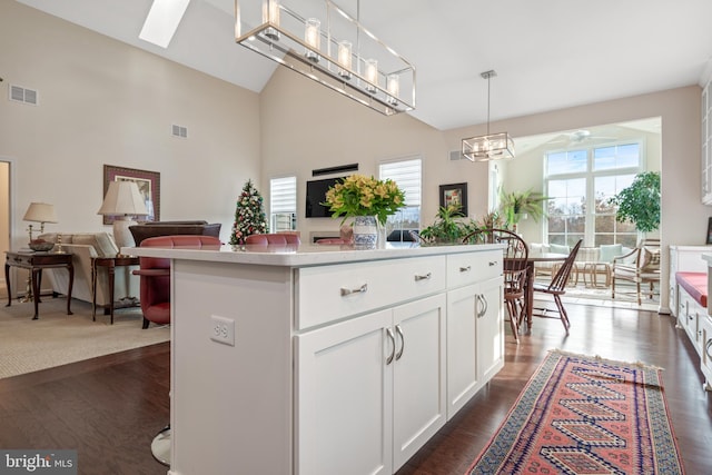 kitchen with white cabinets, a center island, dark hardwood / wood-style floors, and hanging light fixtures