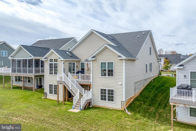 back of house with a yard, a sunroom, and a deck