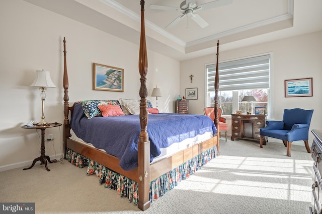 carpeted bedroom featuring ceiling fan, ornamental molding, and a tray ceiling