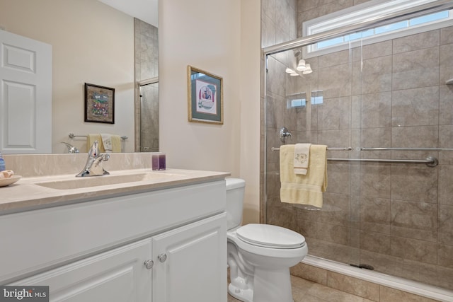 bathroom with vanity, toilet, tile patterned floors, and a shower with door