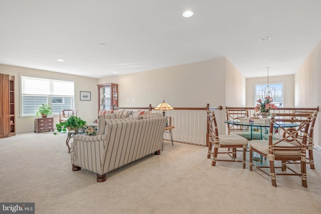 living room with a notable chandelier and light colored carpet