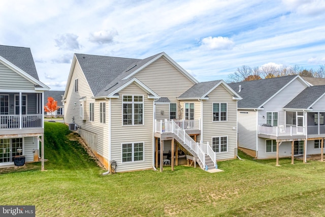 rear view of house featuring a lawn and central AC unit