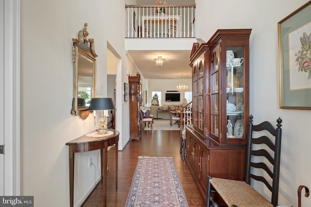 hall with a chandelier and dark hardwood / wood-style floors