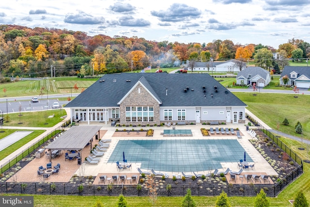 rear view of property featuring a patio and a covered pool