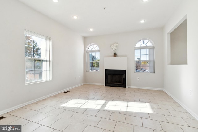 unfurnished living room with light tile patterned floors and plenty of natural light