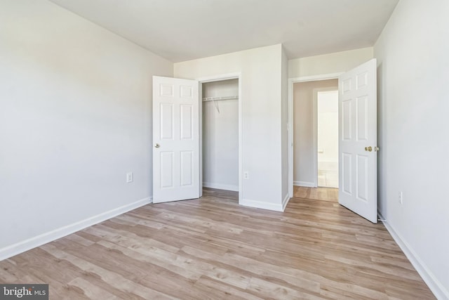 unfurnished bedroom with light hardwood / wood-style flooring and a closet