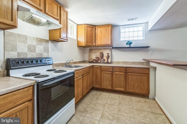 kitchen with light tile patterned floors, decorative backsplash, sink, and white range with electric stovetop