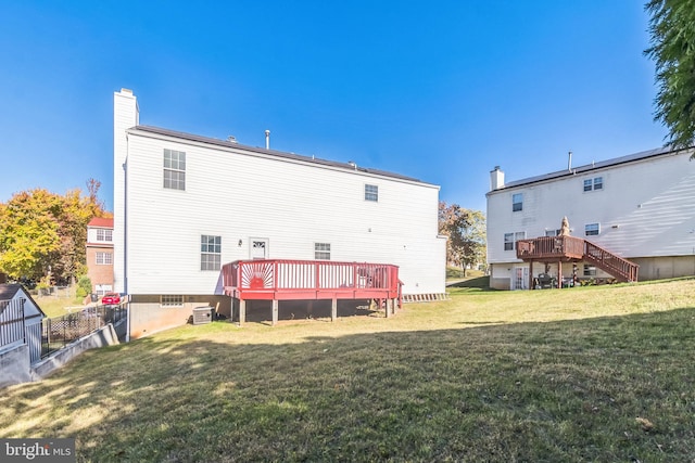 back of property featuring a yard and a deck