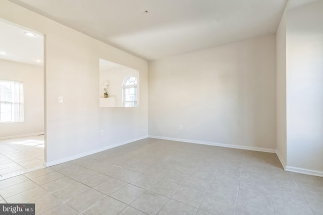 unfurnished room featuring a healthy amount of sunlight and light tile patterned floors